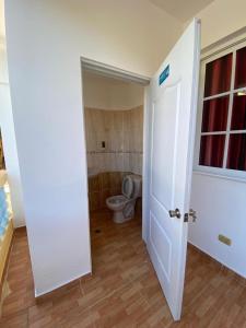 een lege badkamer met een toilet en een deur bij Perfecto para Descansar y Desconectarse Villa Zapata - Apartamentos Turísticos in San Cristóbal