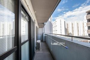 un balcon vide avec vue sur un bâtiment dans l'établissement REBANGA Juso Apartment, à Osaka