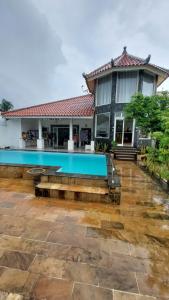 una casa con una piscina di fronte di Mercusuar Resort Jepara a Kesembu