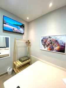 um quarto com uma televisão de ecrã plano na parede em valenshostel em Angra dos Reis