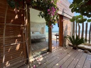 an outdoor room with a bed and flowers on a deck at Alma Loft in Máncora