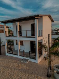 une maison sur la plage avec un palmier dans l'établissement Chalé Galo Preto, à Galinhos