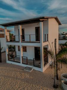 a house on the beach with a palm tree at Chalé Galo Preto in Galinhos +19 photos