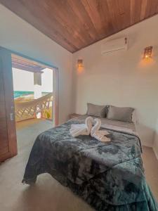 a bedroom with a bed with two towels on it at Chalé Galo Preto in Galinhos