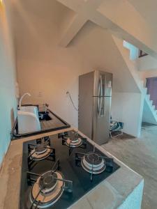 a kitchen with a stove and a refrigerator at Chalé Galo Preto in Galinhos