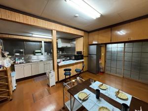 a large kitchen with a table and chairs in it at Snow Fever - Clan in Hakuba