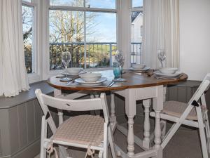 uma sala de jantar com uma mesa e cadeiras e uma janela em Caerleon em Salcombe