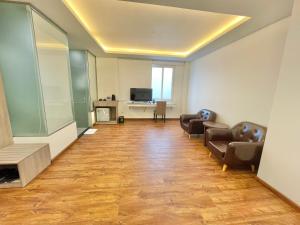 a living room with two chairs and a television at The Mansion Hotel Bien Hoa in Bien Hoa +12 photos