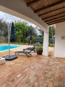 un patio esterno con ombrelloni e piscina di Villa Gwendolin a Portimão