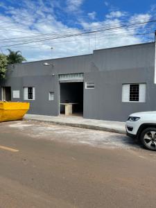 a car parked in front of a building with a garage at HOTEL ARIZON in Inocência