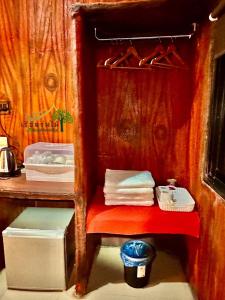 a small room with a red shelf with towels at เรือนร่มไม้รีสอร์ท RuenRomMai Resort in Ban Klang Mun