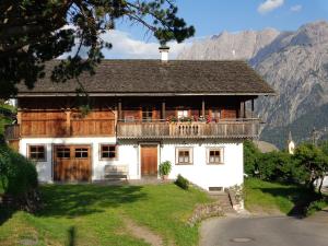 a house in the mountains with mountains in the background at Haus Bachmann in Assling
