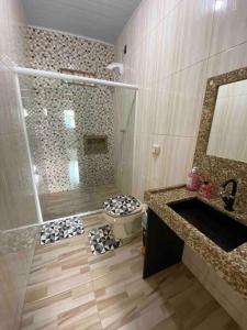 uma casa de banho com um chuveiro, um WC e um lavatório. em Casa de praia em Penha em Penha