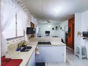 cocina con fregadero y fogones horno superior en Apartamento Vista Linda - com suíte - Bertioga - Prox ao SESC, Riviera, Indaiá, en Bertioga