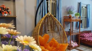 a swing in a room with flowers on the floor at alleyhomestay 2 in Hanoi