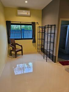 un soggiorno con sedia e finestra di Pool Villa Baan Sanook Cha-am a Petchaburi