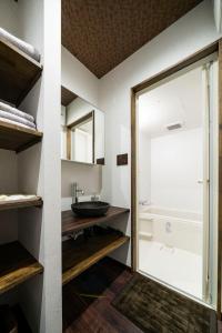 a bathroom with a sink and a mirror at かゑる屋 in Kobe