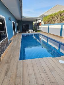 een zwembad met blauw water in een huis bij Pool Villa Baan Sanook Cha-am in Cha Am