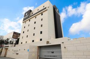 a large white building with a sign on it at Mari Hotel Terminal Branch in Jeonju