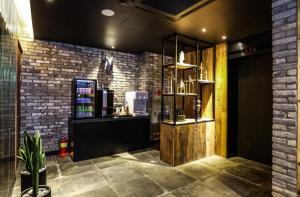 a coffee shop with a counter and a brick wall at Mari Hotel Terminal Branch in Jeonju