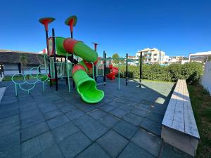 Tourist complex City Center Oued Laou في Oued Laou: ملعب مع زحليقة خضراء في حديقة