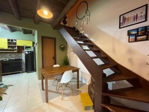 uma cozinha e sala de jantar com uma escada e uma mesa em Casa inteira sozinha no pátio com estacionamento - Guarda do Embaú em Guarda do Embaú