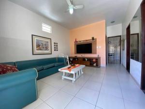 a living room with a couch and a tv at Casa entre Cabo Frio e Arraial do Cabo in Cabo Frio