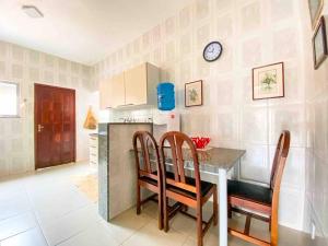 a kitchen with a table and chairs and a clock on the wall at Casa entre Cabo Frio e Arraial do Cabo in Cabo Frio