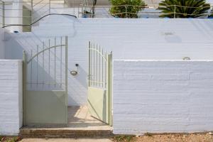 a white fence with a gate and a white wall at Nefeles Arkadiko Chorio in rkadiko Chorio