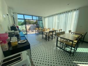 a dining room with tables and chairs and a balcony at แอ่ว-ดีLD Hotel&Residences in Ngao