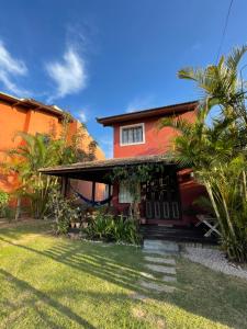 una casa con techo rojo y algunas palmeras en CASA PRIVATIVA - 5 pessoas- Guarda do Embaú, en Guarda do Embaú