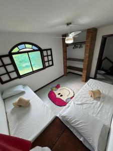 a bedroom with two beds and a window at Casa PraiaRasa in Armacao dos Buzios