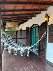 a hammock on the porch of a house at Casa PraiaRasa in Armacao dos Buzios