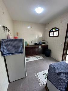 uma cozinha com um frigorífico branco num quarto em Casa PraiaRasa em Armacao dos Buzios