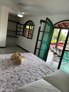 a bedroom with a bed and a view of a pool at Casa PraiaRasa in Armacao dos Buzios
