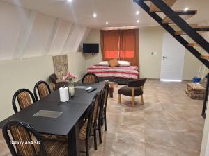 a dining room with a table and chairs and a bed at Cabañas Alpinas in Mendoza