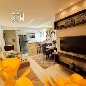 a living room with a large television and a dining room at Charmoso apartamento, Beto Carrero, Homeclub, Mar in Penha
