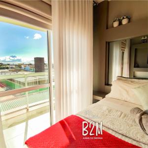 a bedroom with a bed and a balcony with a view at Charmoso apartamento, Beto Carrero, Homeclub, Mar in Penha