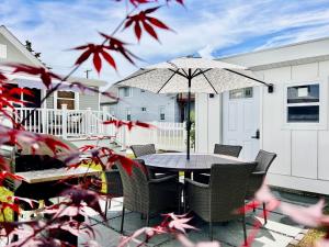 a table with chairs and an umbrella on a patio at Unique Wildwood 3 BR 1,5 BA Entire House in the Heart of Wildwood! in Wildwood