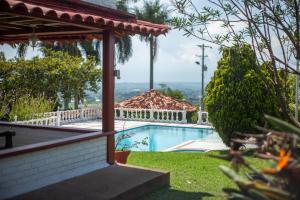 a swimming pool in a yard with a gazebo at Finca con hermosa vista, billar pool, piscina, atardeceres in Pereira