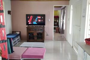 a living room with a flat screen tv on a cabinet at Finca con hermosa vista, billar pool, piscina, atardeceres in Pereira