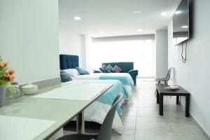 sala de estar con 2 camas y sofá en Apartaestudios, La Castilla Avenida de los Estudiantes, en Pasto