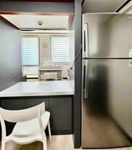 a kitchen with a stainless steel refrigerator and a white chair at Gasan Duplex - Female Only in Seoul
