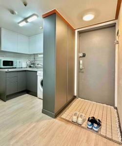 首爾的住宿－Gasan Duplex - Female Only，厨房的地板上设有一扇带鞋的门
