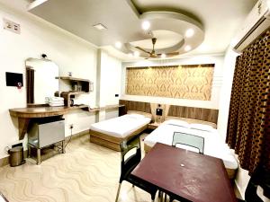 Hotel Samrat في Baharampur: غرفة مستشفى بسريرين وطاولة