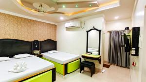 Hotel Samrat في Baharampur: غرفة صغيرة بسريرين ومرآة