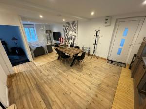 Charmant grand Appartement في Serdinya: غرفة معيشة مع طاولة وكراسي خشبية