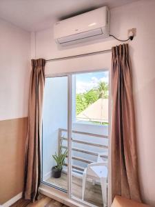a room with a large window and a balcony with a balcony at Raalhu Fonu Maldives in Mahibadhoo