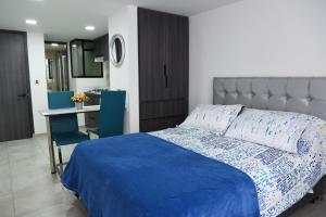 1 dormitorio con cama, mesa y escritorio en Apartaestudios, La Castilla Avenida de los Estudiantes, en Pasto