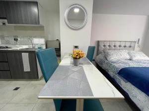 Un dormitorio con una cama y una mesa con flores. en Apartaestudios, La Castilla Avenida de los Estudiantes, en Pasto